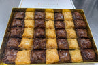 Box of assorted baklava with visible brand name on a gray background