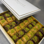 Box of baklava with green pistachio on a metallic surface
