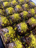 Chocolate pastry baklava squares filled and topped with premium ground pistachios.