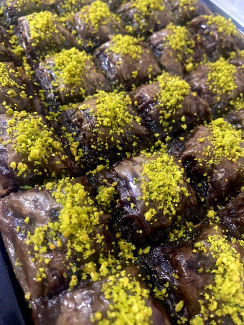 Chocolate pastry baklava squares filled and topped with premium ground pistachios.