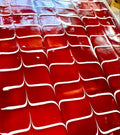 A tray of Trilece milk cake with a bright red raspberry glaze and decorative white cream.