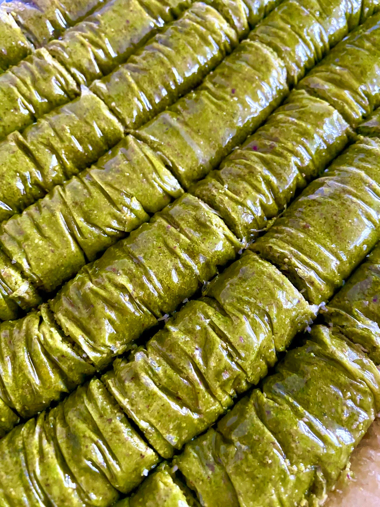Close-up of signature Pistachio Sarma rolls, made almost entirely of crushed pistachios and thin pastry.