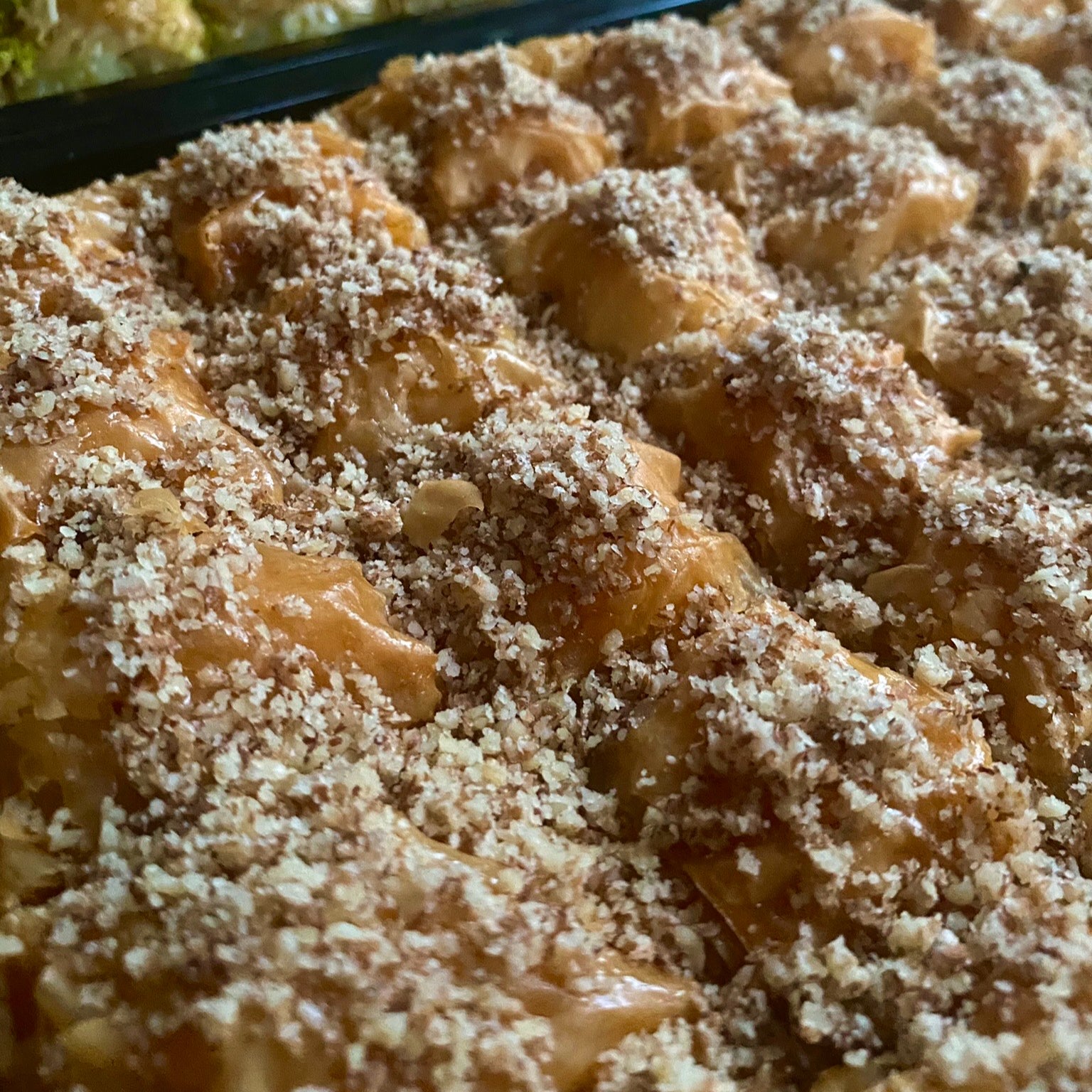 A freshly baked tray of traditional walnut baklava with a crispy golden-brown texture.