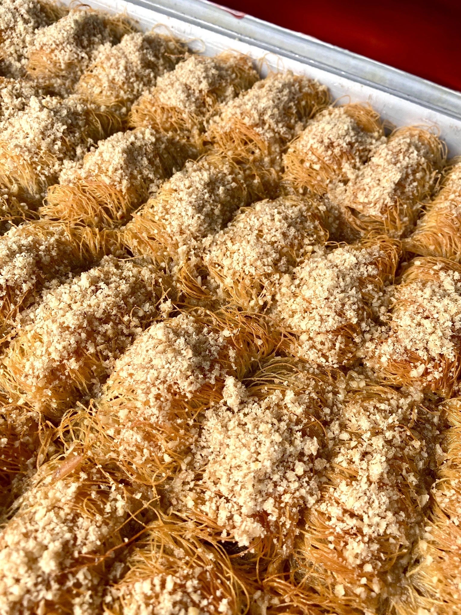 Golden rolls of shredded kadayif pastry filled and topped with crushed walnuts.